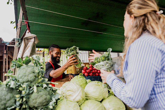 A clerk helping a woman with produce